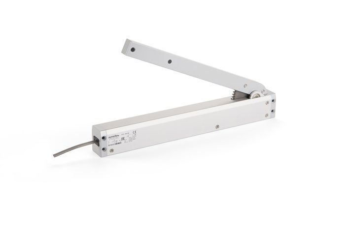 A silver mechanical arm housing with a connected cable, featuring industrial labeling and mounting points, designed for precise linear motion control in window actuators.
