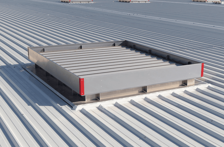 A rectangular ventilation unit on a corrugated metal roof enhances natural ventilation.
