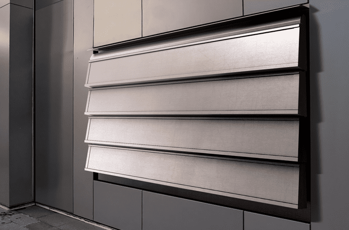 A metallic, horizontally-louvered window shade with window actuators is partially open on a modern building facade.