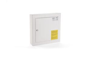 A closed, wall-mounted metal electrical panel box with a keyhole, a small label on the top right, and a large yellow warning label towards the bottom on a plain white background, commonly used in smoke ventilation systems.