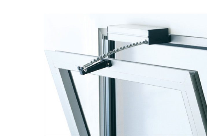A motorized window opener with a chain drive system attached to the top of a tilted window frame ensures seamless natural ventilation.