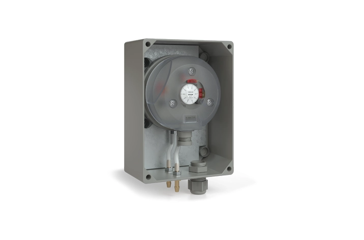 A gray industrial pressure switch with a transparent cover is mounted on a rectangular metal box.